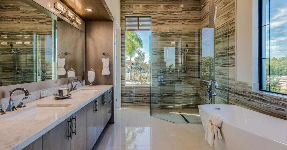 Luxury bathroom remodel featuring a freestanding tub, glass shower enclosure, custom wood cabinetry, and modern marble finishes